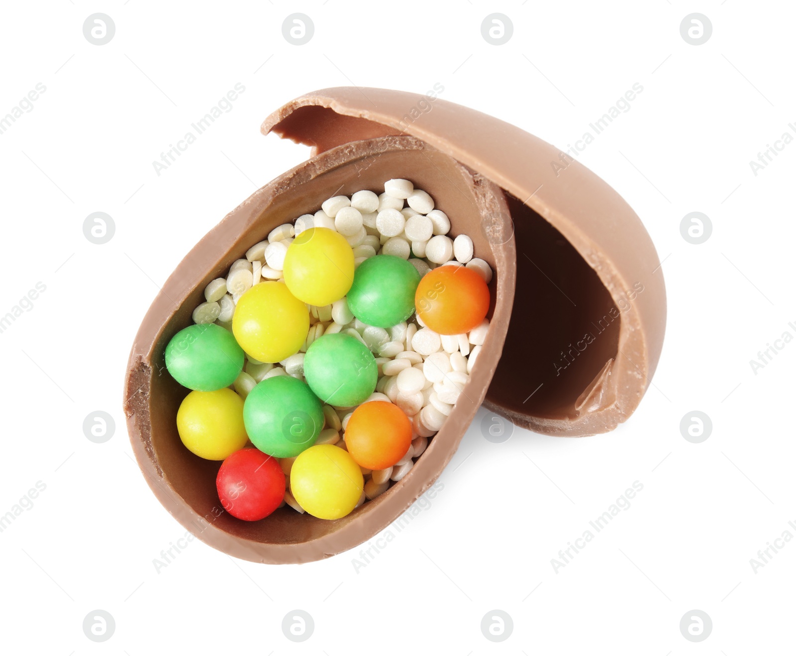 Photo of Broken chocolate Easter egg with colorful candies on white background, top view