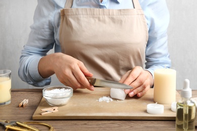 Photo of Woman making decorative aroma candle at table, closeup