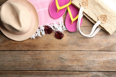 Beach accessories on wooden table, flat lay. Space for text