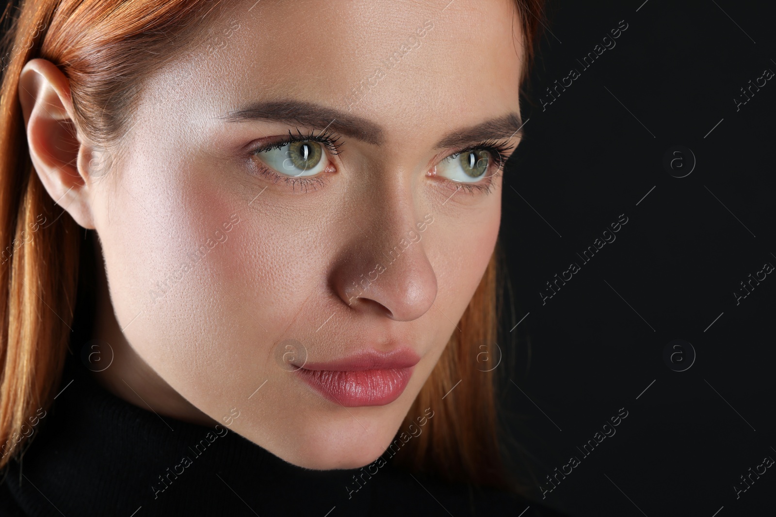 Photo of Evil eye. Young woman with scary eyes on black background, closeup. Space for text