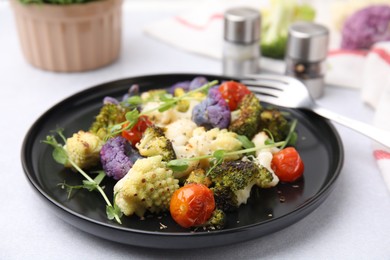 Delicious salad with cauliflower and tomato served on white table, closeup