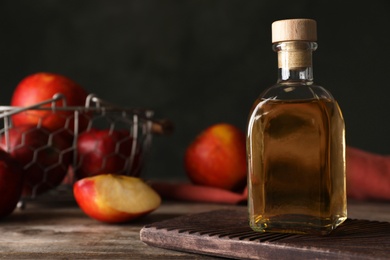 Photo of Composition with bottle of apple vinegar on table. Space for text