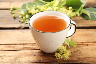 Cup of tea and linden blossom on wooden table