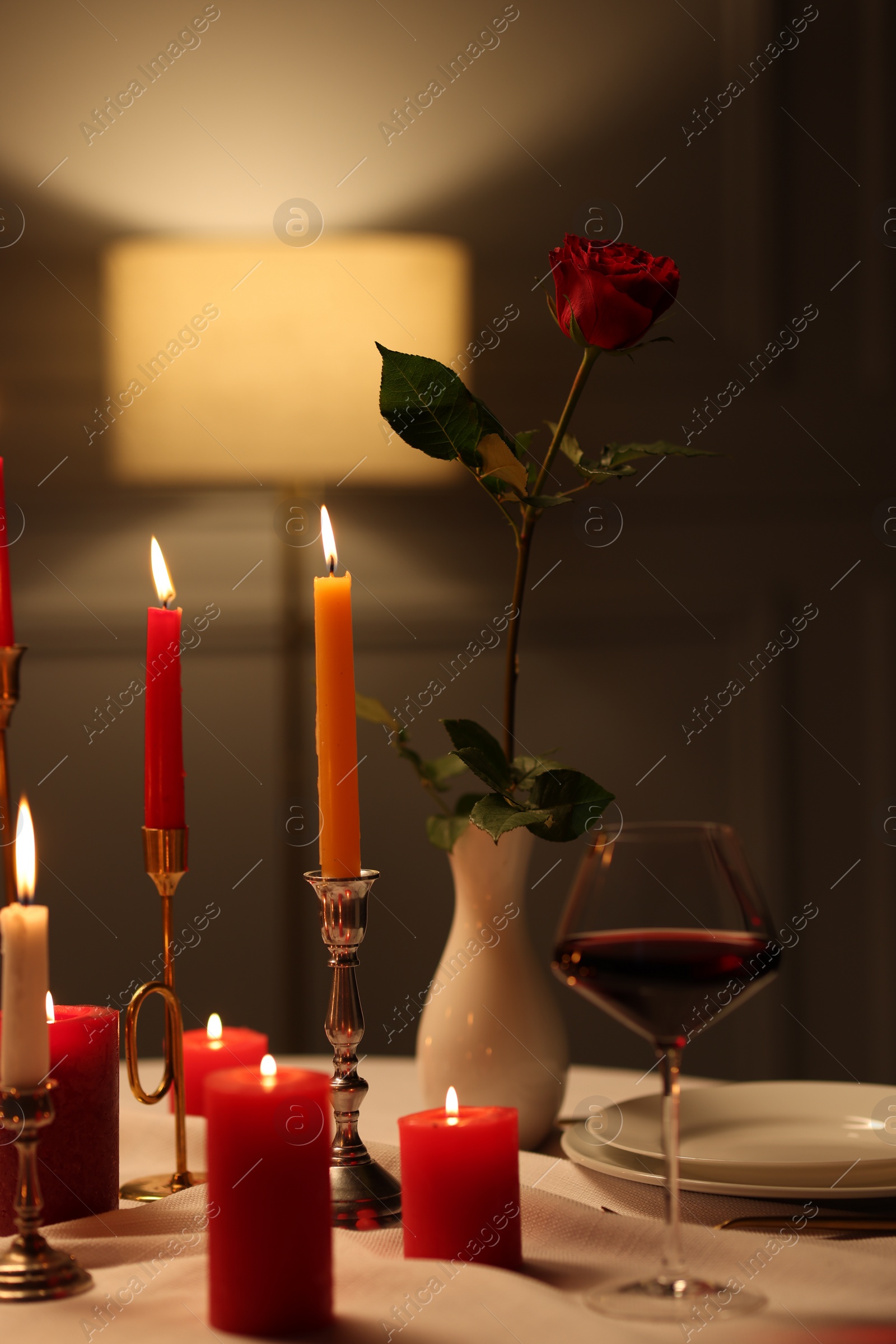 Photo of Elegant table setting with burning candles in restaurant