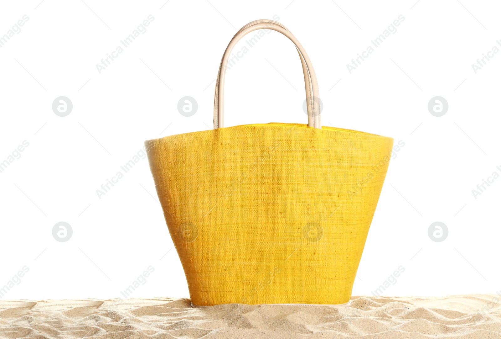 Photo of Stylish yellow bag on sand against white background