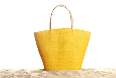 Photo of Stylish yellow bag on sand against white background