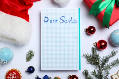Photo of Card with words DEAR SANTA and Christmas decorations on white background, top view. Space for text
