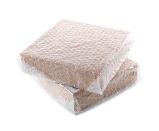 Photo of Cardboard boxes packed in bubble wrap on white background