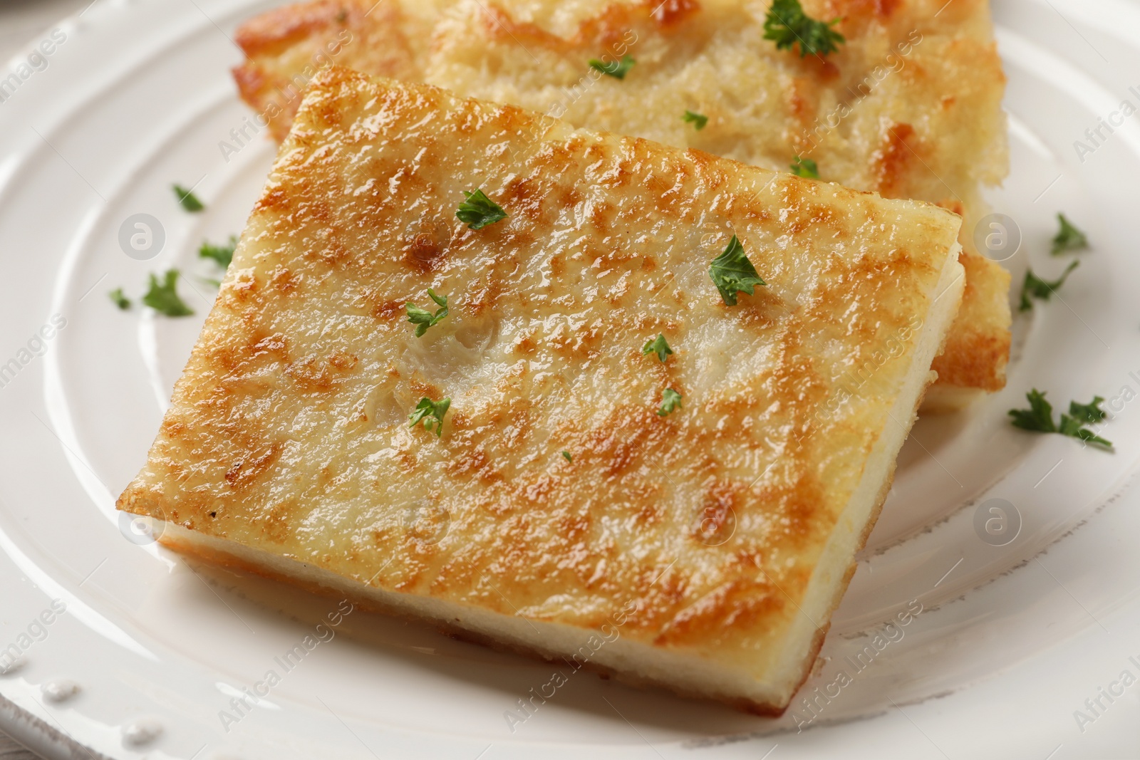 Photo of Delicious turnip cake with parsley on plate, closeup