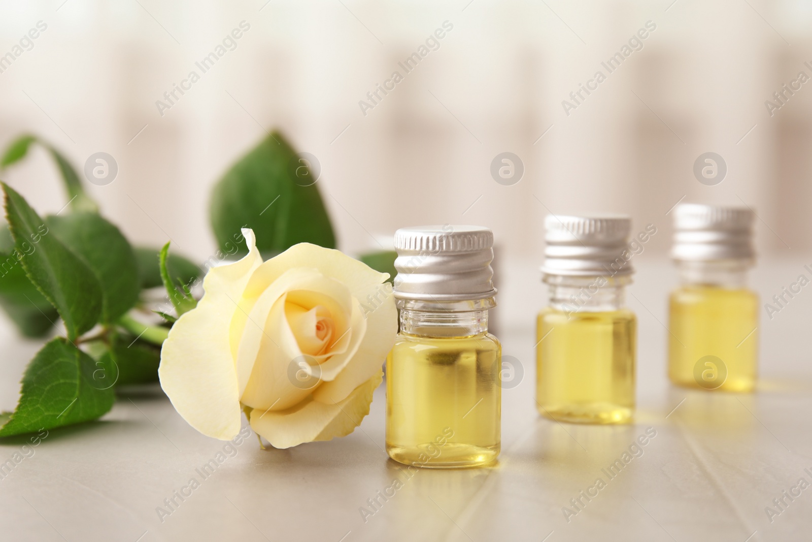 Photo of Composition with essential oil and flower on table