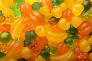 Photo of Mix of different delicious gummy candies as background, top view