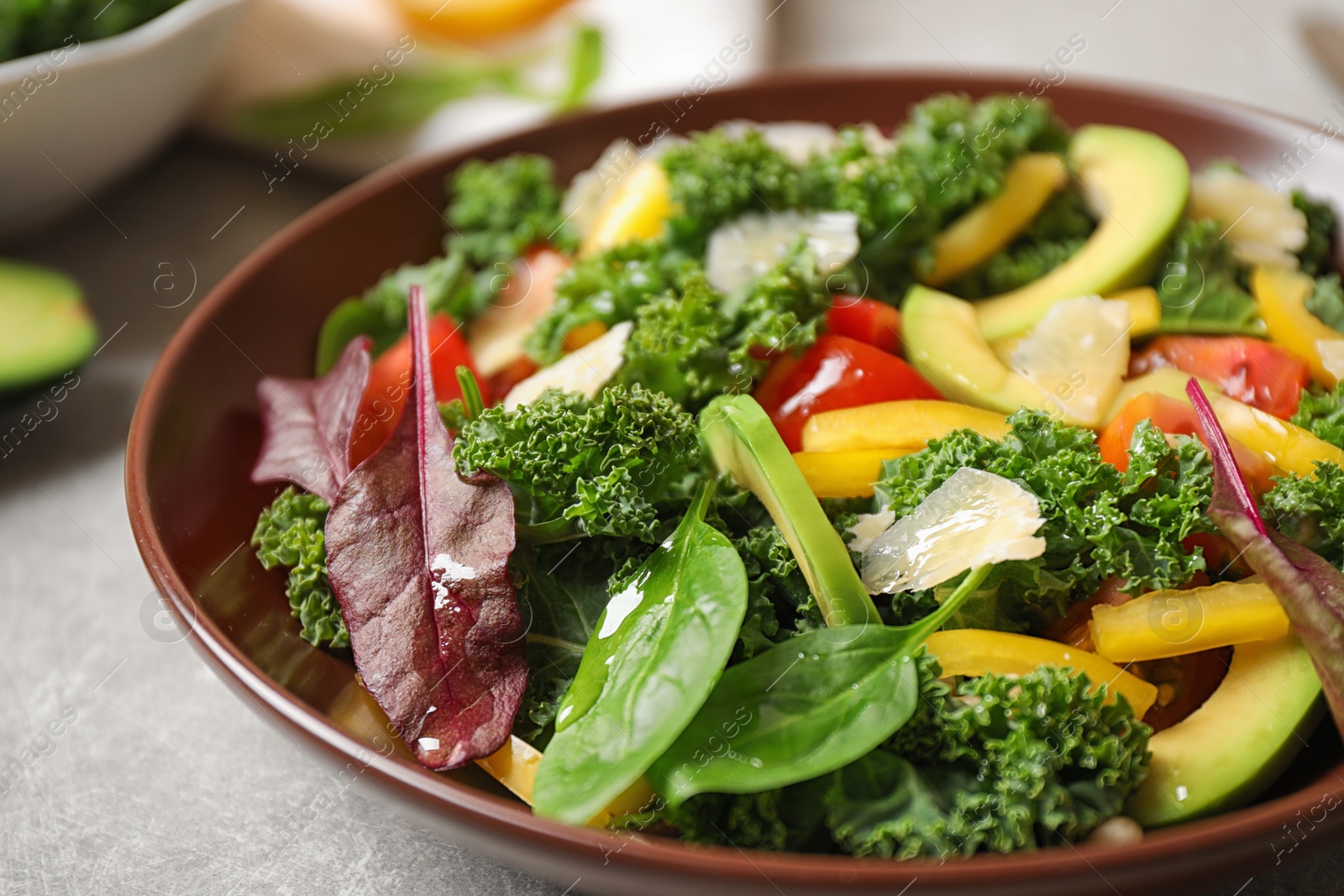 Photo of Tasty fresh kale salad on light grey table, closeup