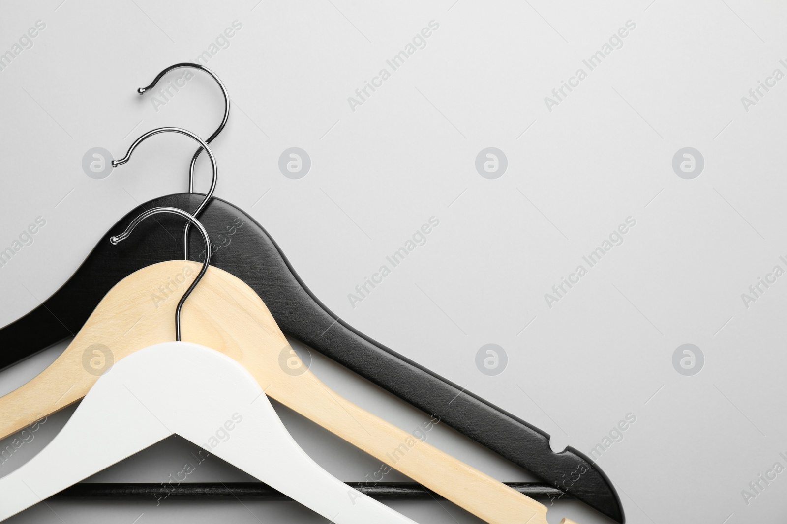 Photo of Hangers on light gray background, top view. Space for text