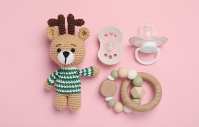 Photo of Flat lay composition with pacifiers and other baby stuff on pink background