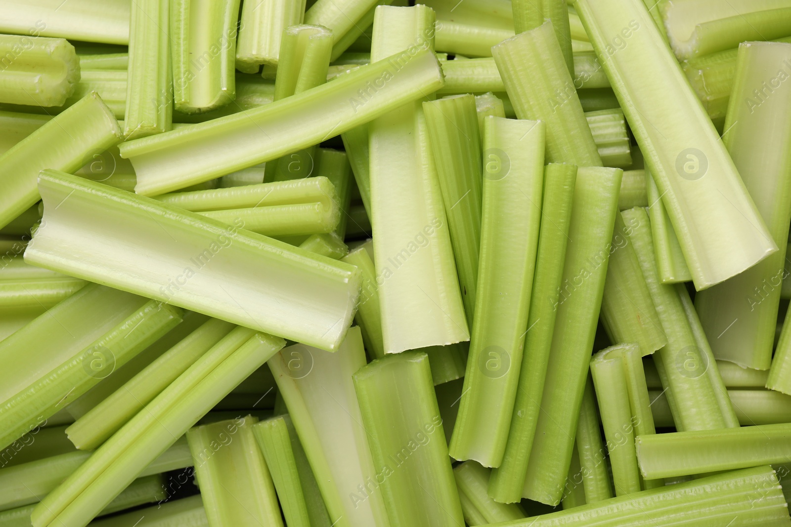 Photo of Fresh green cut celery as background, top view