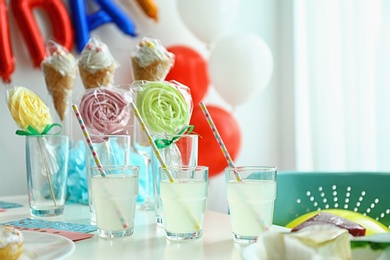 Photo of Table with delicious treats and blurred balloons on background