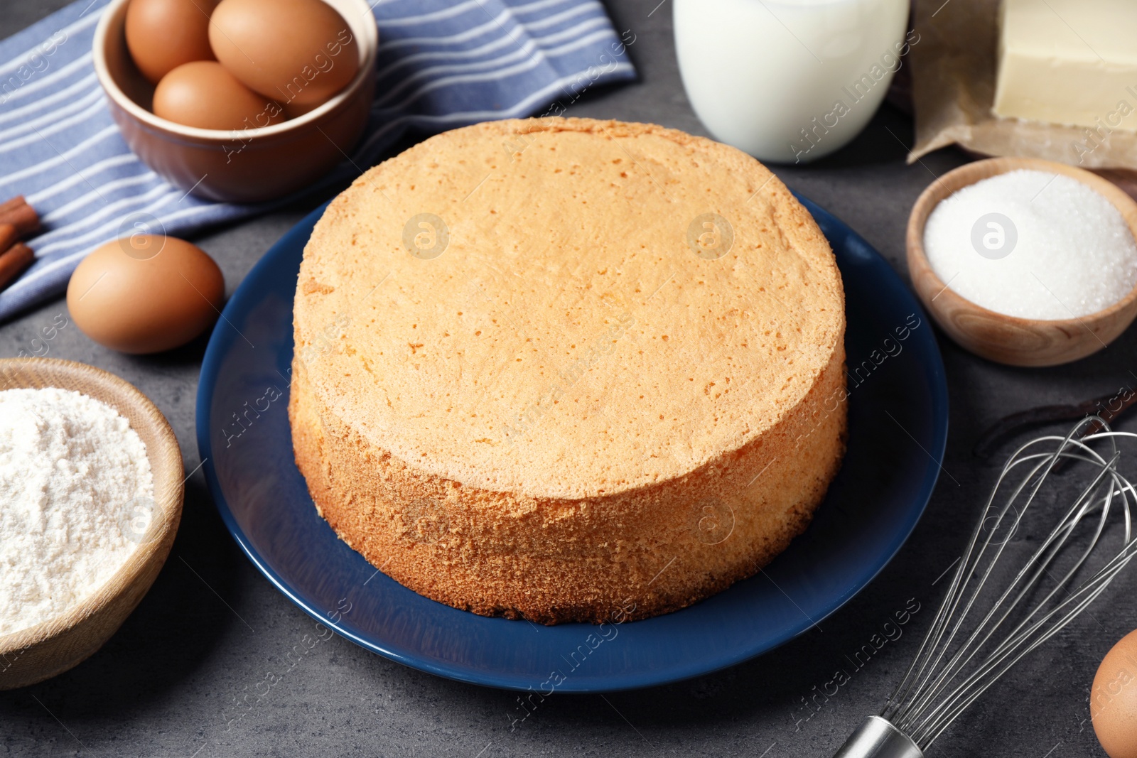 Photo of Delicious fresh homemade cake and ingredients on grey marble table