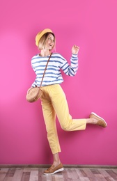 Photo of Beautiful young woman posing near color wall. Summer fashion