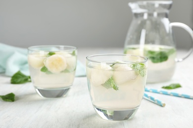 Glasses with tasty melon ball drinks on light table