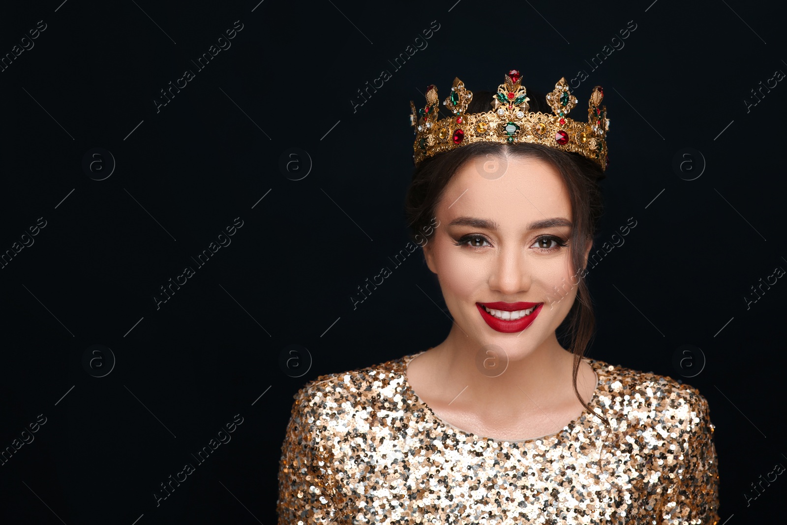 Photo of Beautiful young woman wearing luxurious crown on black background, space for text