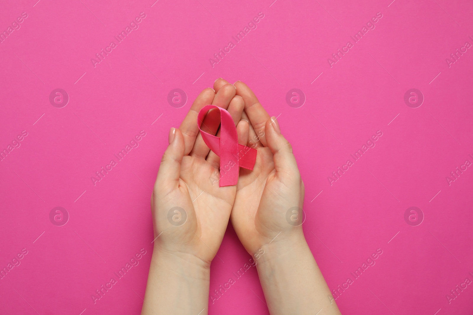 Photo of Woman with pink ribbon on color background, top view. Breast cancer awareness