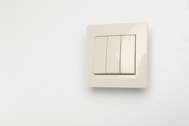 Photo of Modern light switch on white background. Space for text