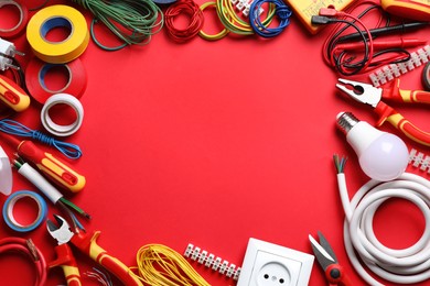 Photo of Frame of electrician's tools and accessories on red background, flat lay. Space for text