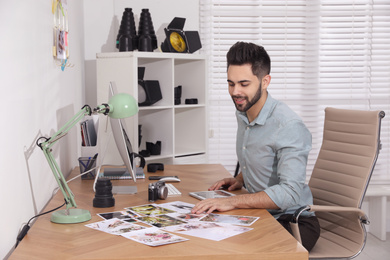 Photo of Professional photographer working at table in office