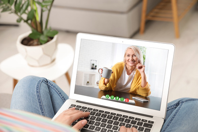 Young woman having video chat with her grandmother at home, focus on screen