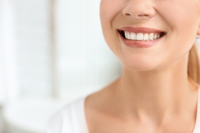 Photo of Young woman with beautiful smile indoors. Teeth whitening