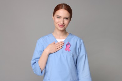 Photo of Mammologist with pink ribbon on gray background. Breast cancer awareness