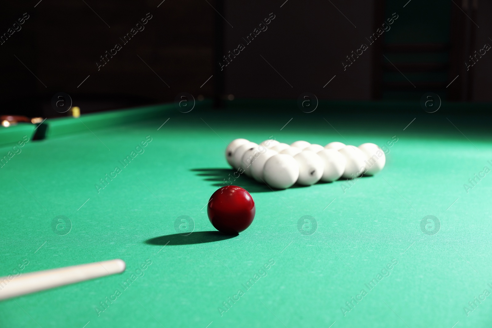 Photo of Striking ball with cue on billiard table