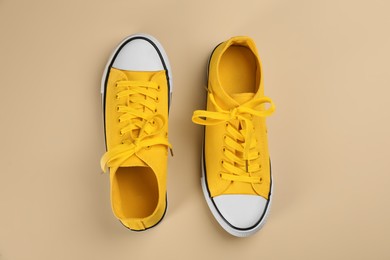 Photo of Stylish sneakers on beige background, flat lay