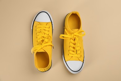 Stylish sneakers on beige background, flat lay