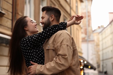 Photo of Lovely couple dancing together on city street, space for text