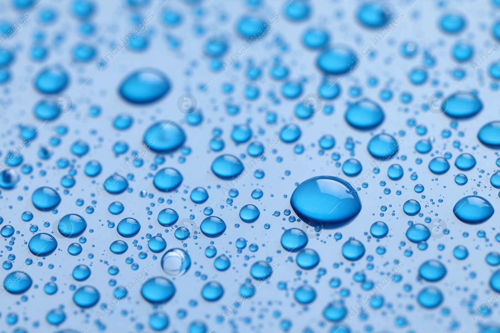 Photo of Water drops on blue background, closeup view