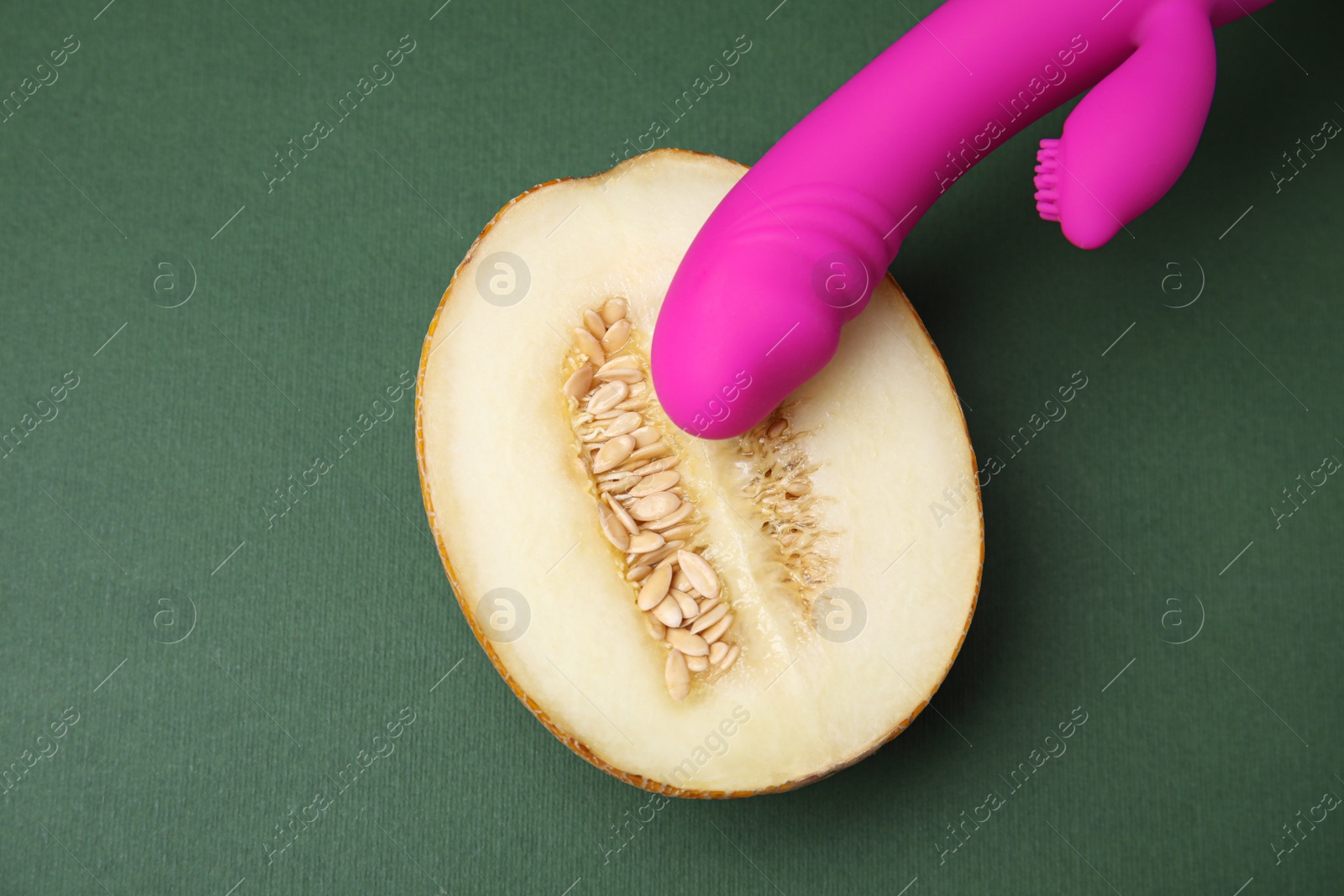 Photo of Half of melon and purple vibrator on dark grey background, flat lay. Sex concept