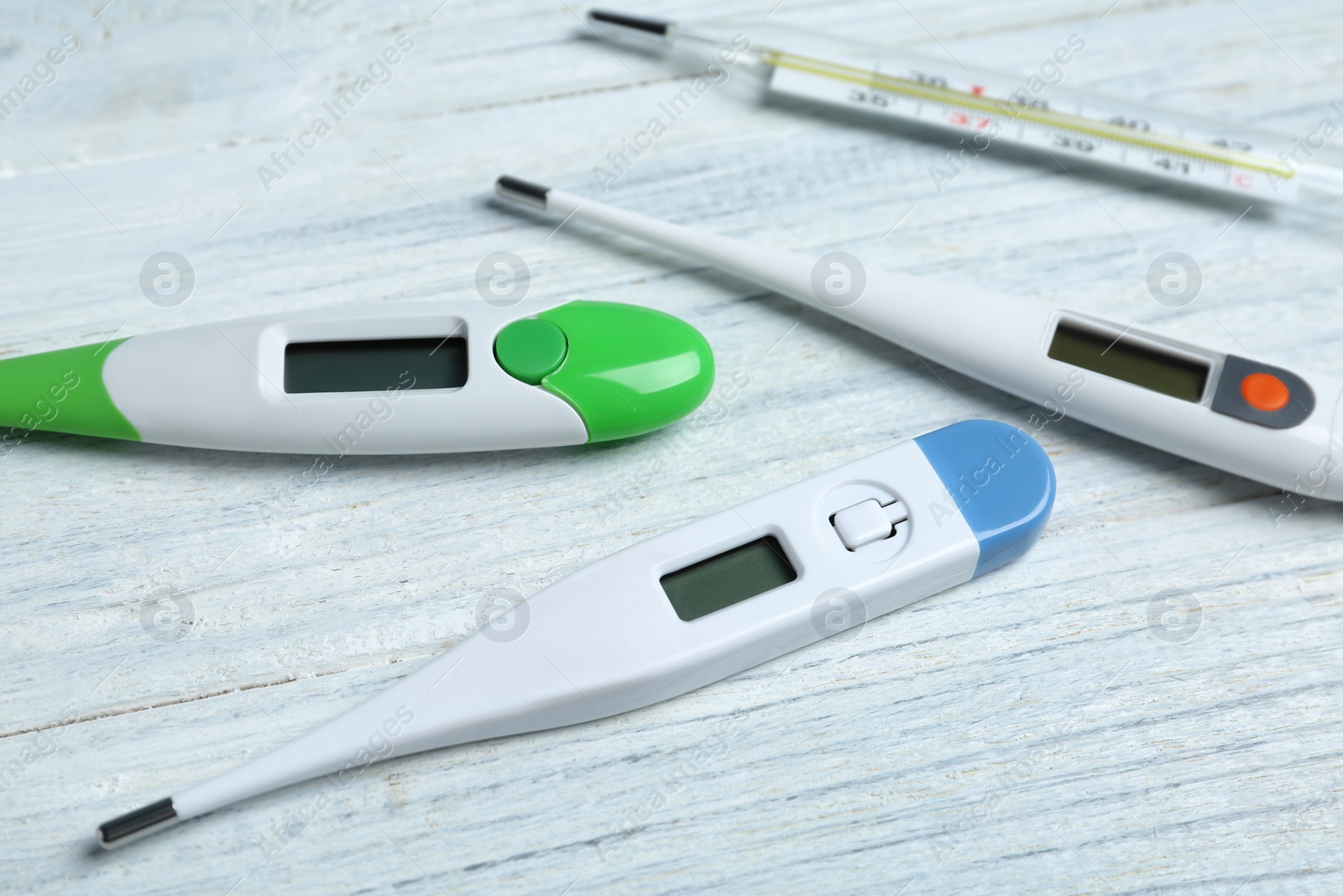 Photo of Different thermometers on white wooden background, closeup