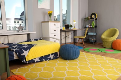 Stylish child room interior with comfortable bed and workplace