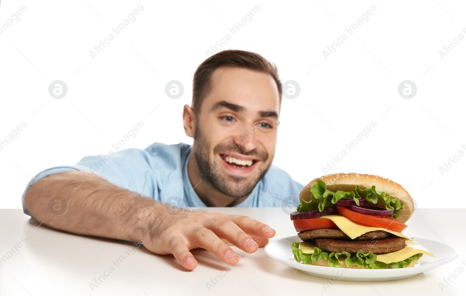 Photo of Young hungry man with tasty burger on white background