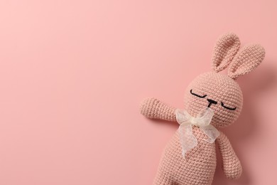 Photo of Baby accessory. Toy rabbit on pink background, top view. Space for text