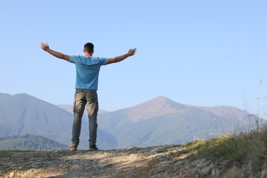 Photo of Man enjoying picturesque mountain landscape, back view. Space for text