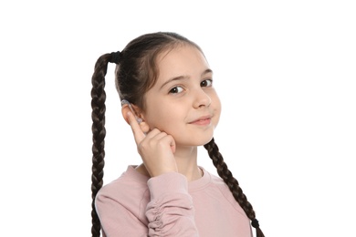 Photo of Little girl adjusting hearing aid on white background