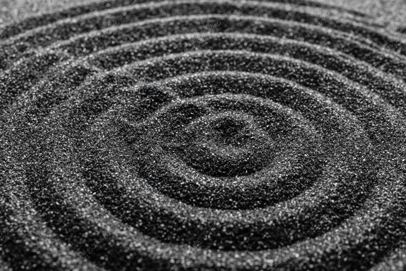 Photo of Black sand with beautiful pattern, closeup. Zen concept