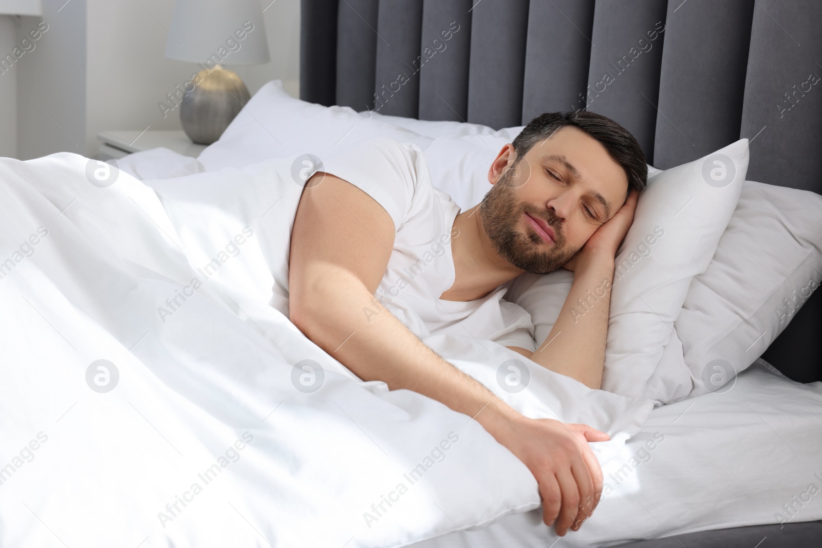 Photo of Handsome man sleeping in soft bed at home