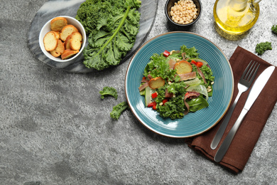 Delicious kale salad on grey table, flat lay