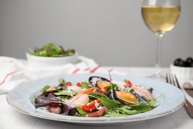 Photo of Platedelicious salad with seafood on white tiled table