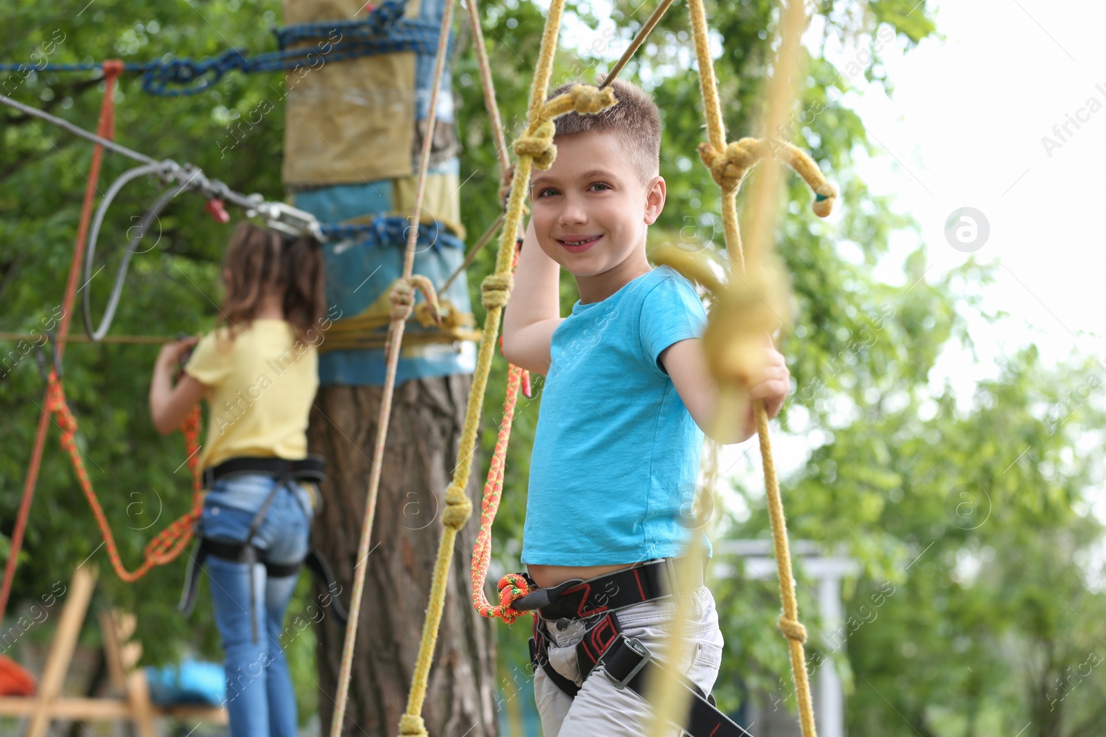 Photo of Little boy climbing in adventure park. Summer camp