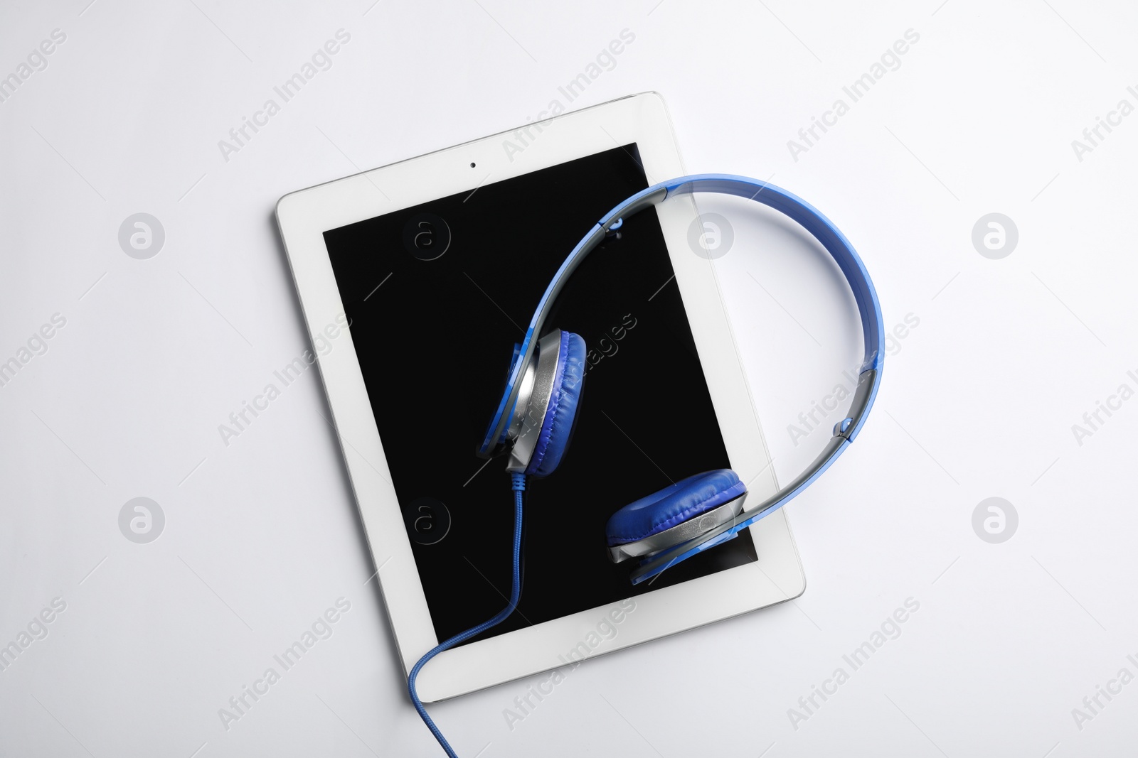 Photo of Stylish headphones and modern tablet on white background, top view