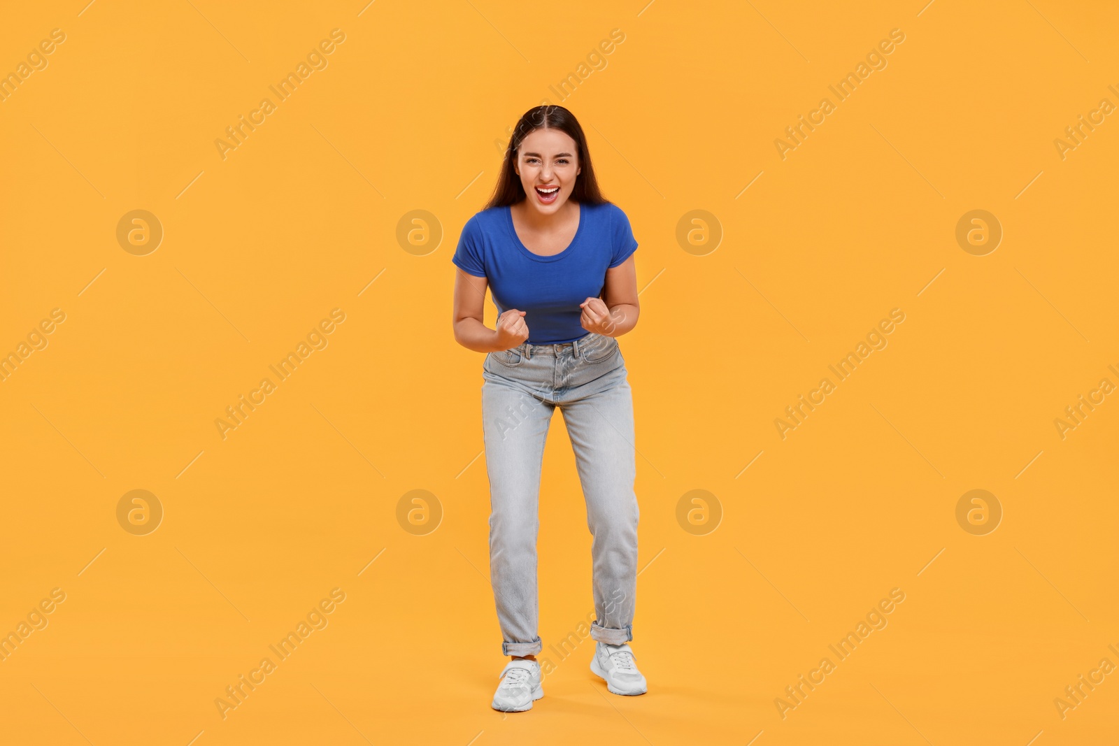 Photo of Happy sports fan celebrating on yellow background